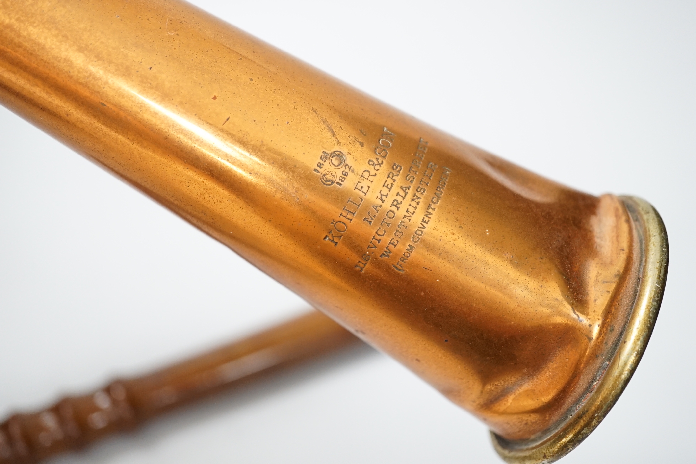A copper hunting horn by Kohler & Son, a.f., in leather case and a turned wood truncheon, the largest 88cm in length